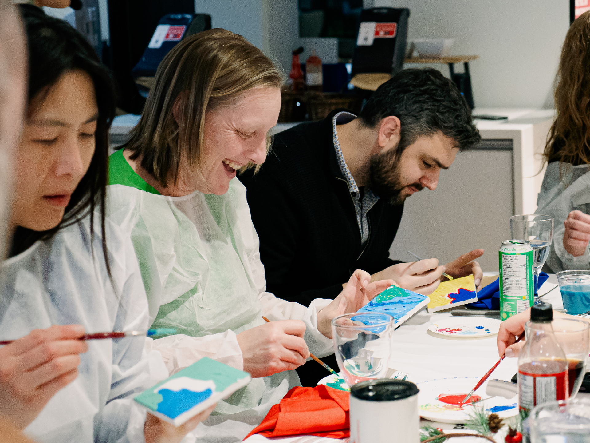 Team members laughing while painting together