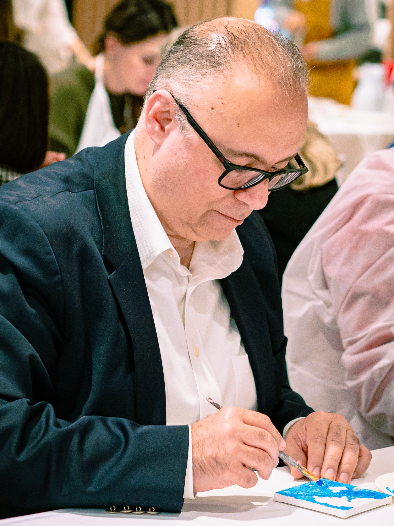 Executive focused on painting a small canvas